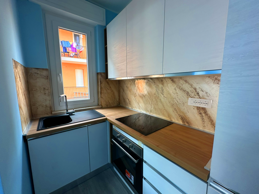 Cucina ristrutturata a Borghetto Santo Spirito con parete del piano cottura rivestita in pietra spaccata
